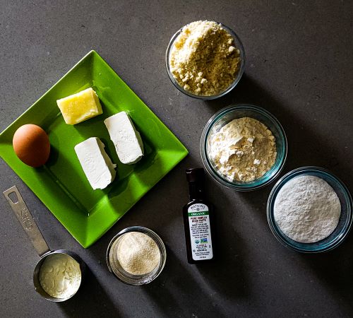 Cookie ingredients of almond flour, coconut flour, egg white protein powder, gelatin, Allulose, vanilla, butter, cream chees, and an egg